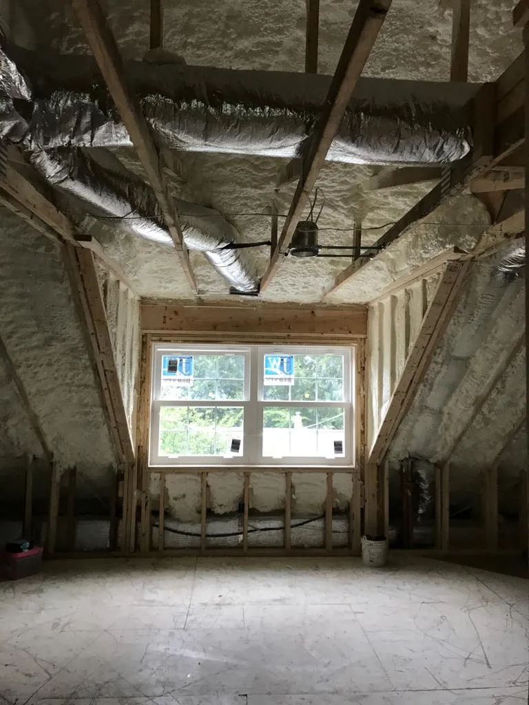 Attic spray foam at a roofline window